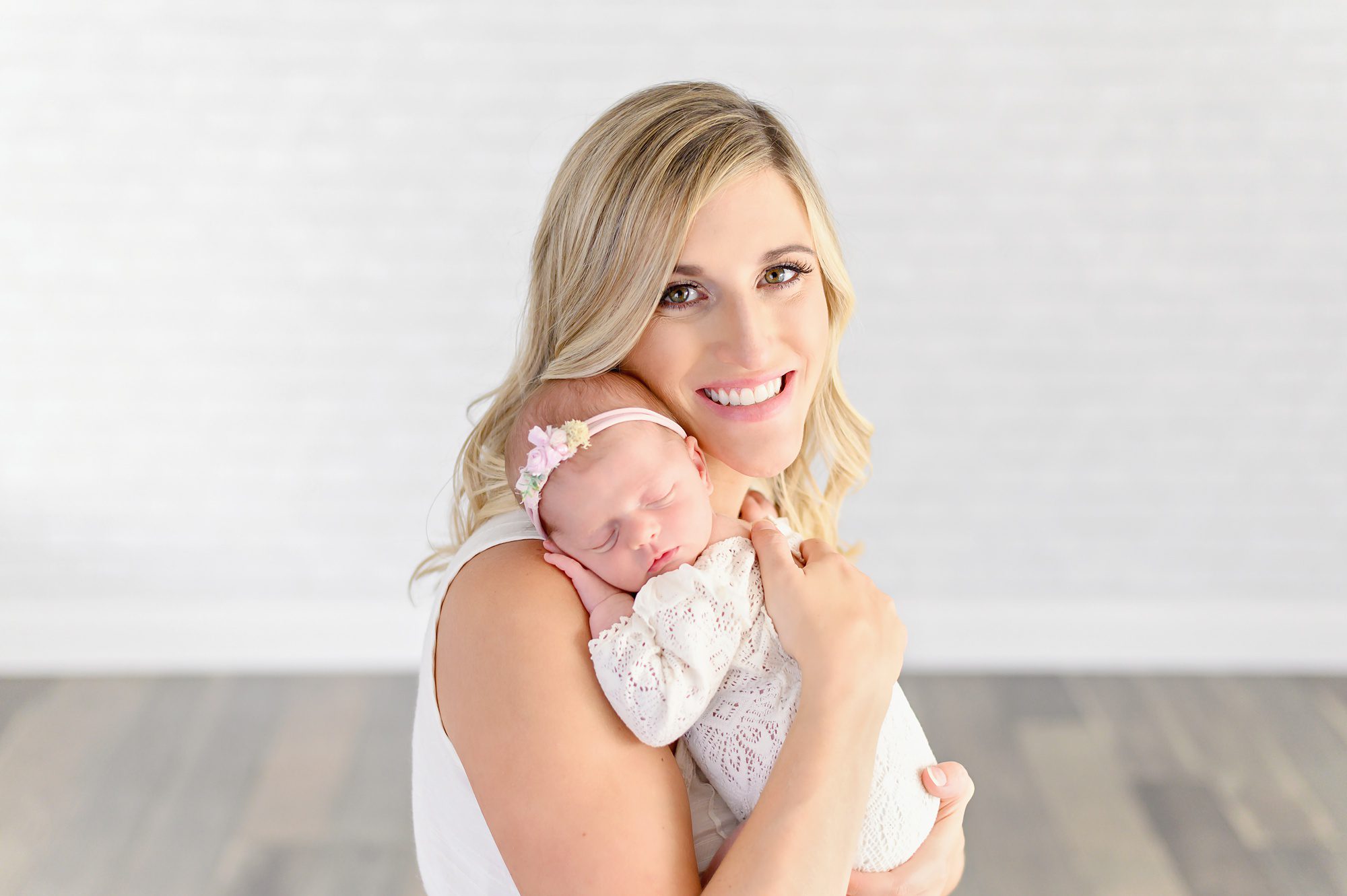 A young family of 4 with a new baby girl gets newborn portraits done in a bright white studio in Tampa Florida.