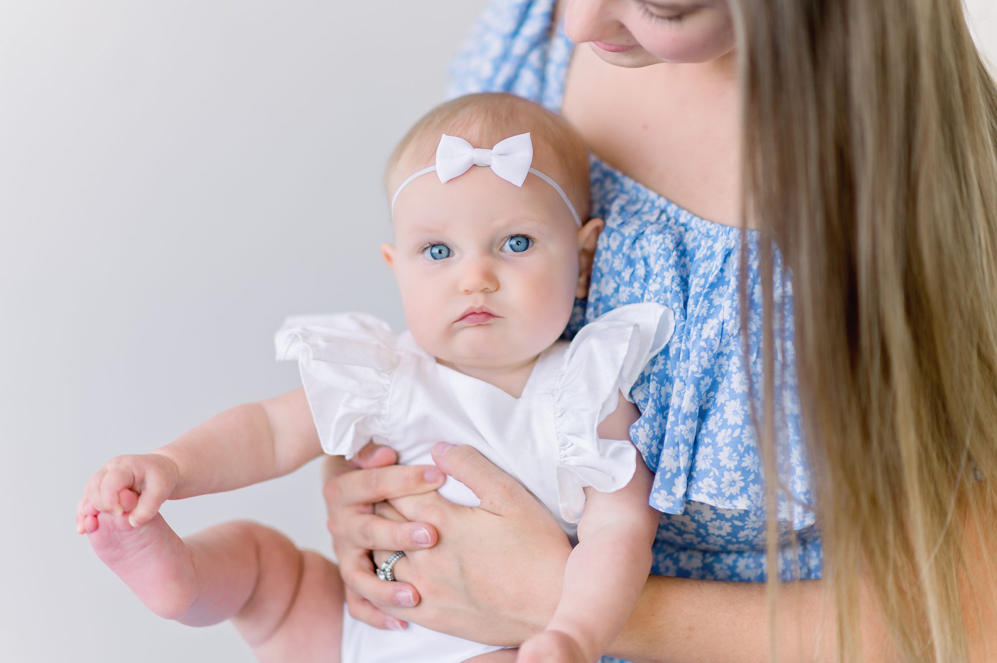 A stunning young mom gets portraits done in a photography studio in Denver with her adorable 7 month old daughter.