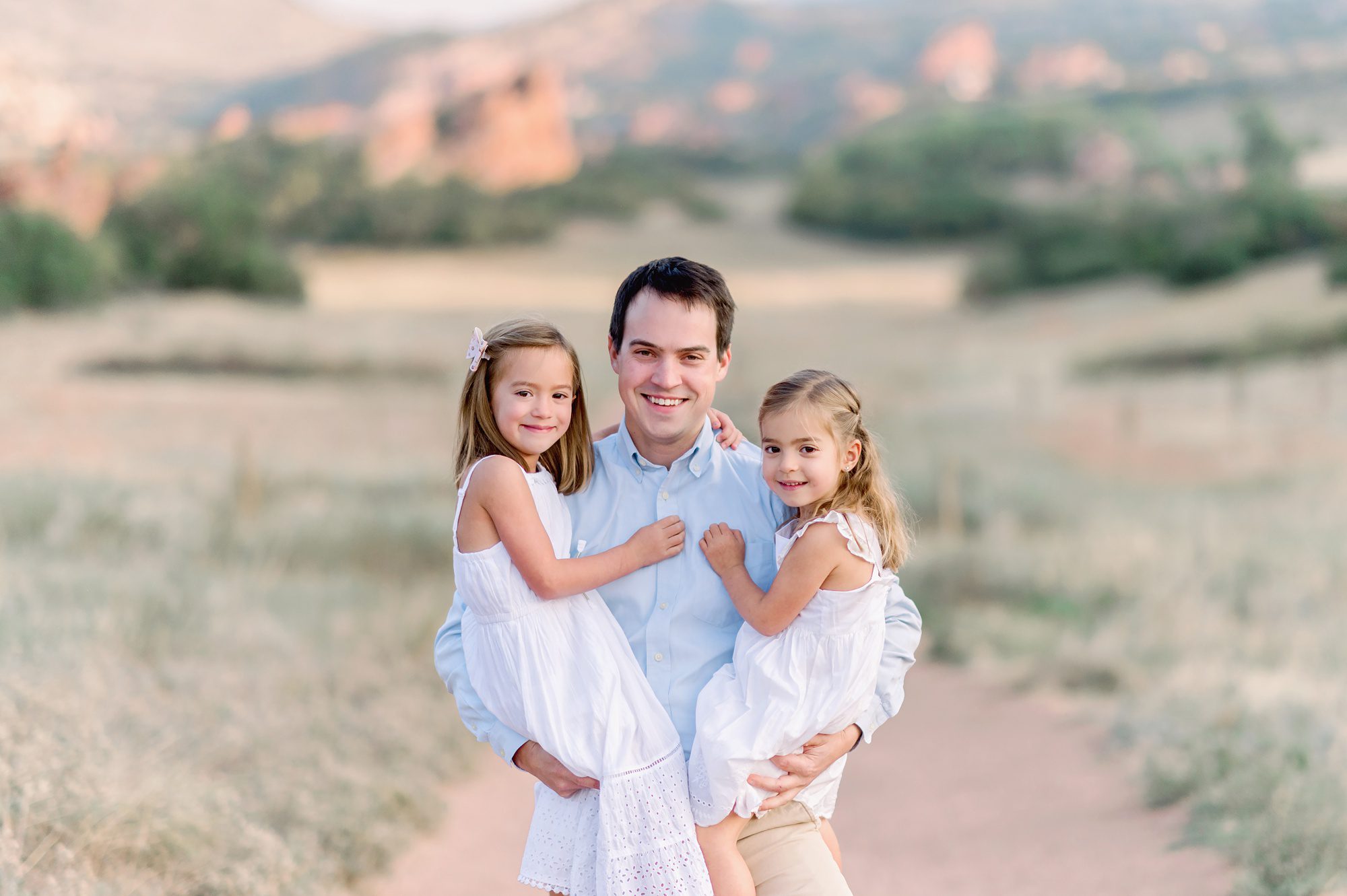 Parents with their two young daughters get fall family photos done at South Valley Park in Ken Caryl, Colorado. 