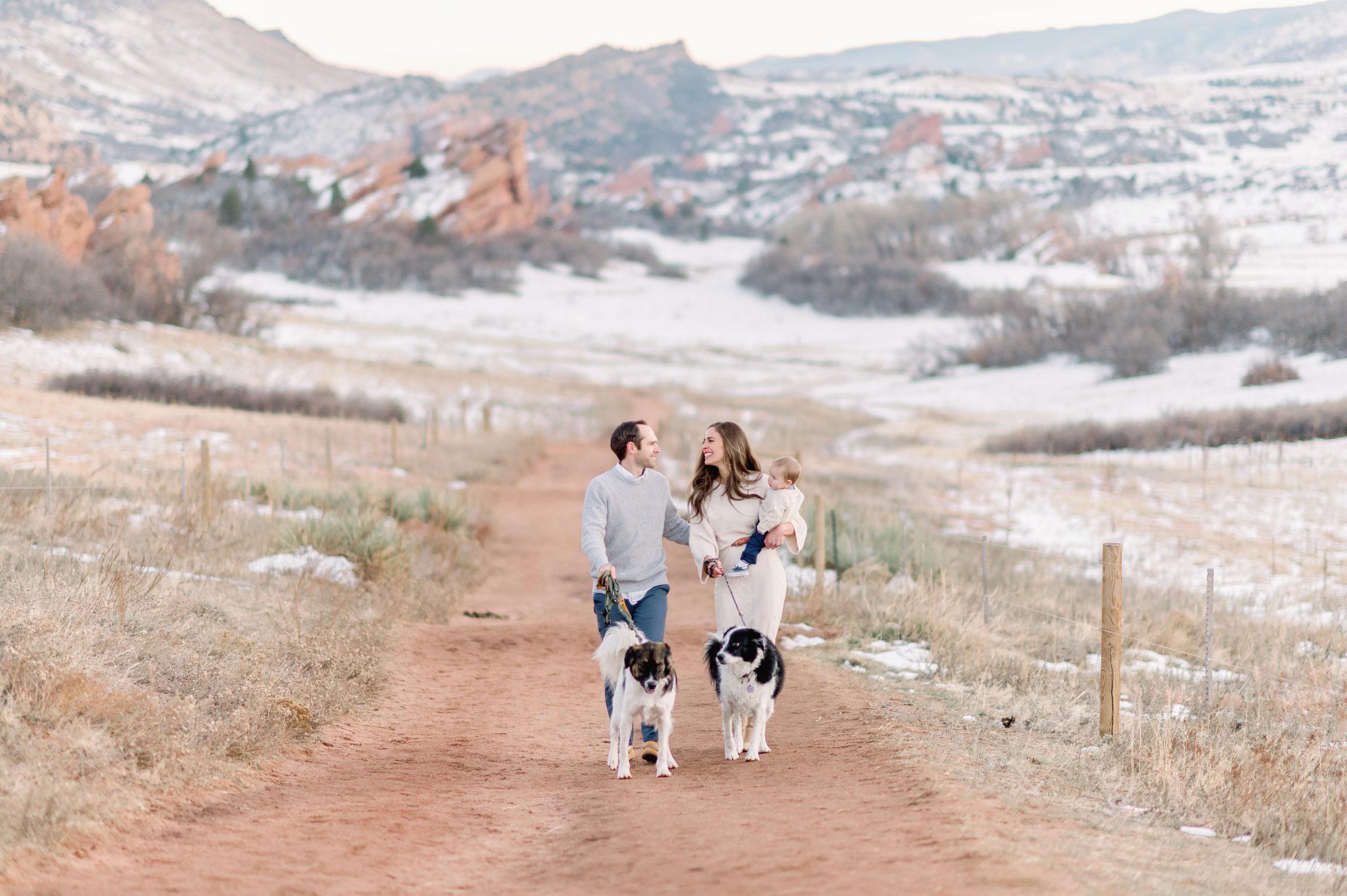 A young beautiful family of 3 get family portraits taken with a beautiful mountain backdrop at South Valley Park in Littleton Colorado.