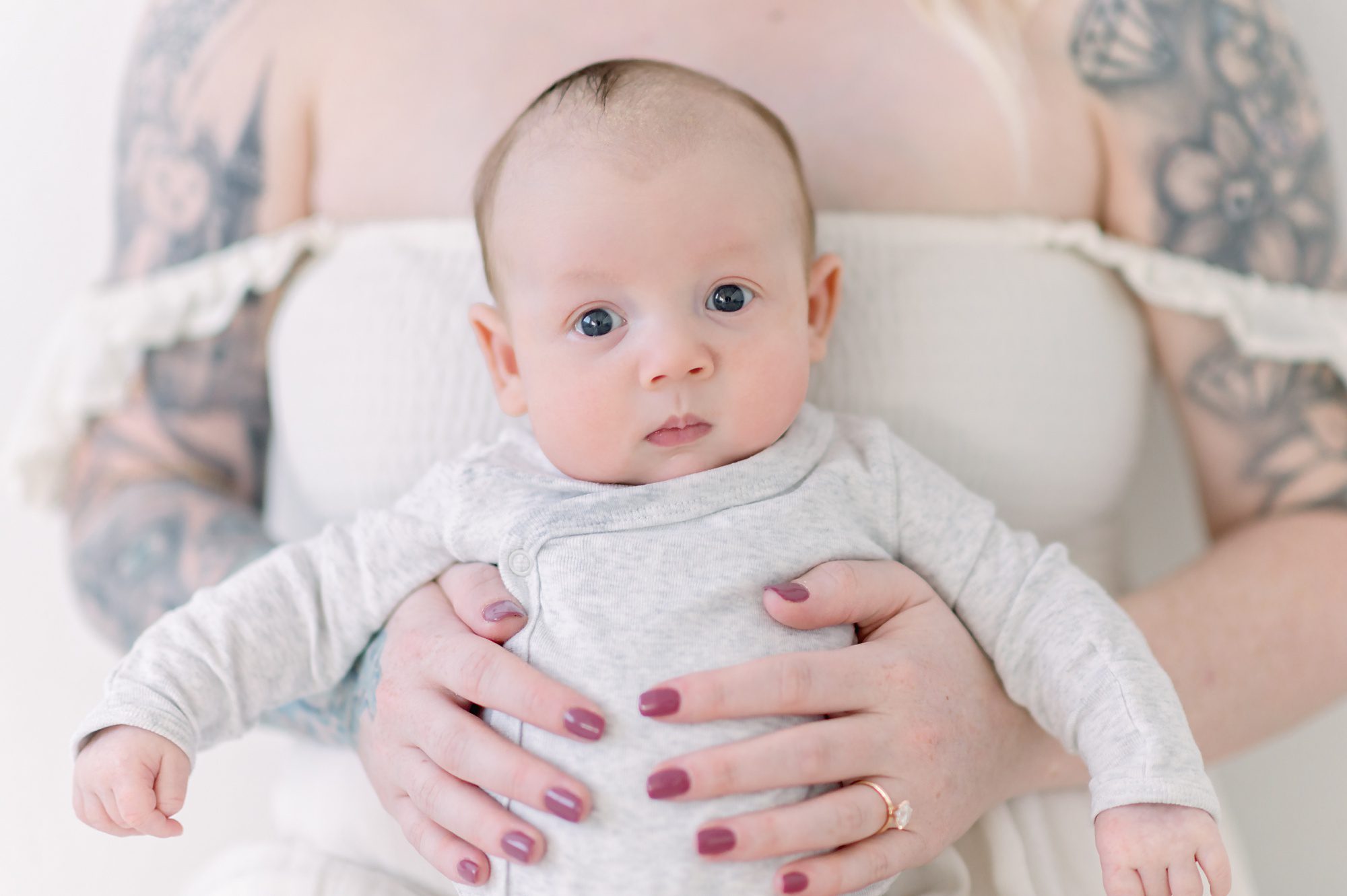 As a new family of 4, these parents get light and airy newborn photos done with their two boys in a bright white studio in Denver Colorado.