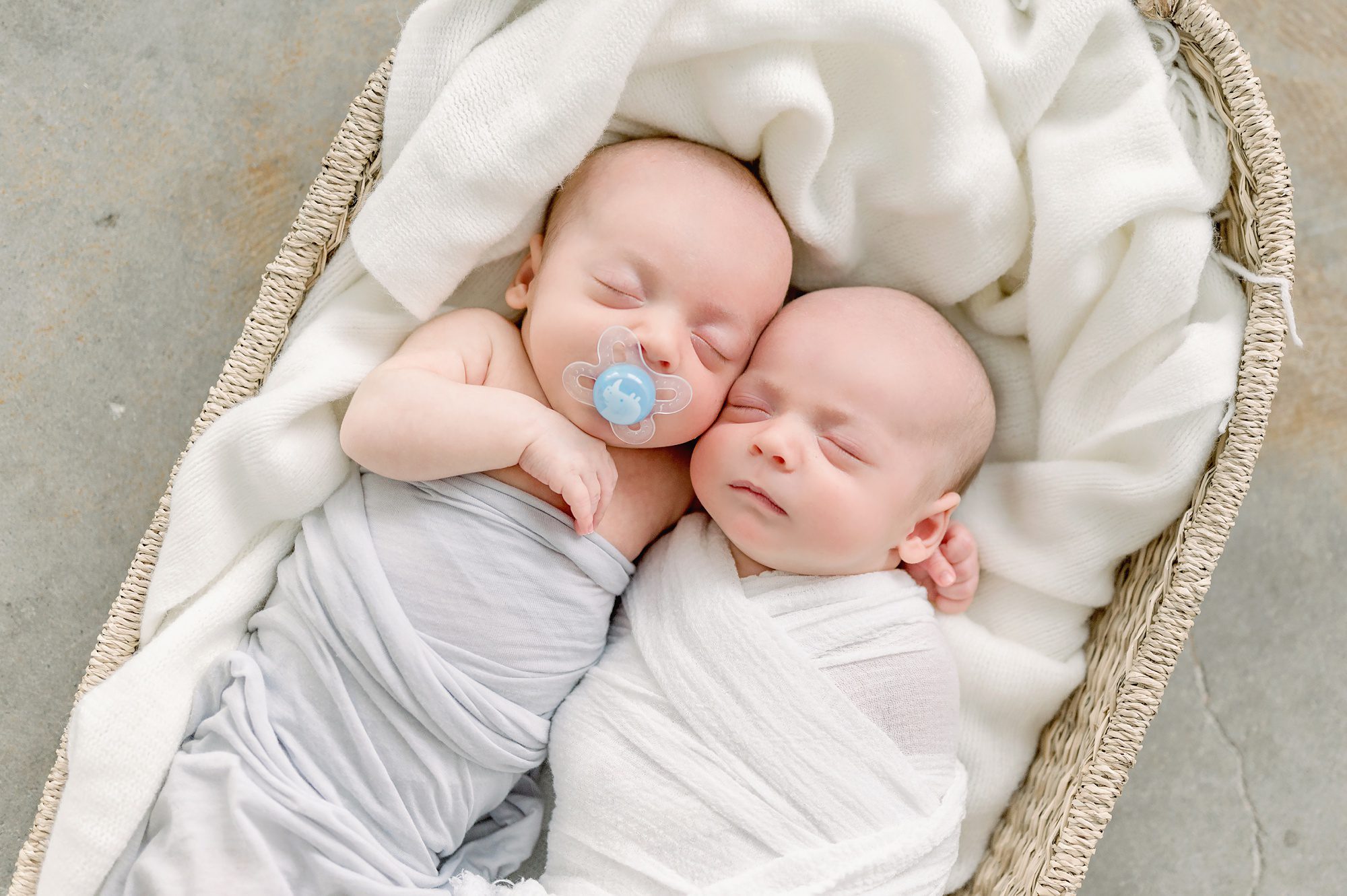 A family of five with newborn twin boys gets family photos done in a bright white studio in Denver Colorado with their older son.